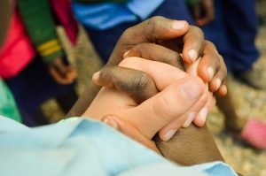 Volunteer and child holding hands in Zambia.