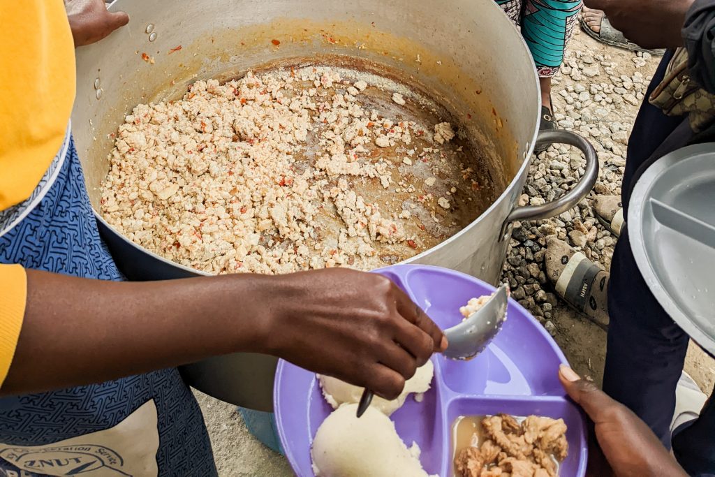 A woman scooping egg relish and putting it on a child's plate.