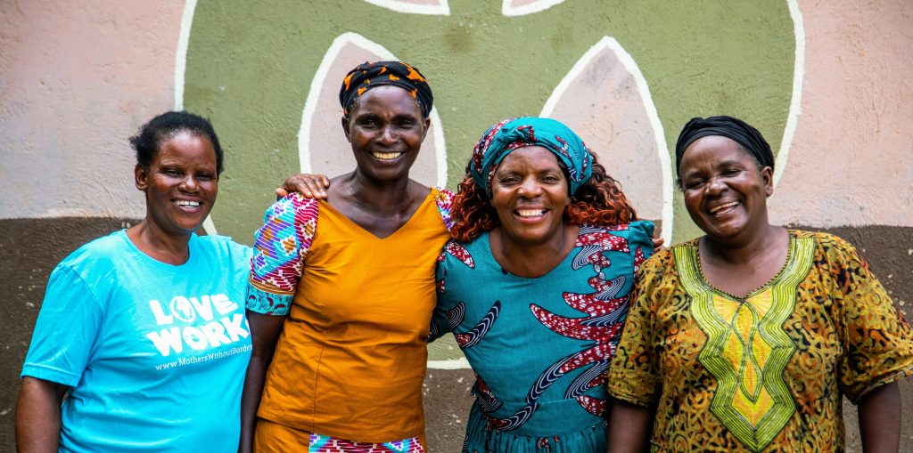 Four women smiling together.