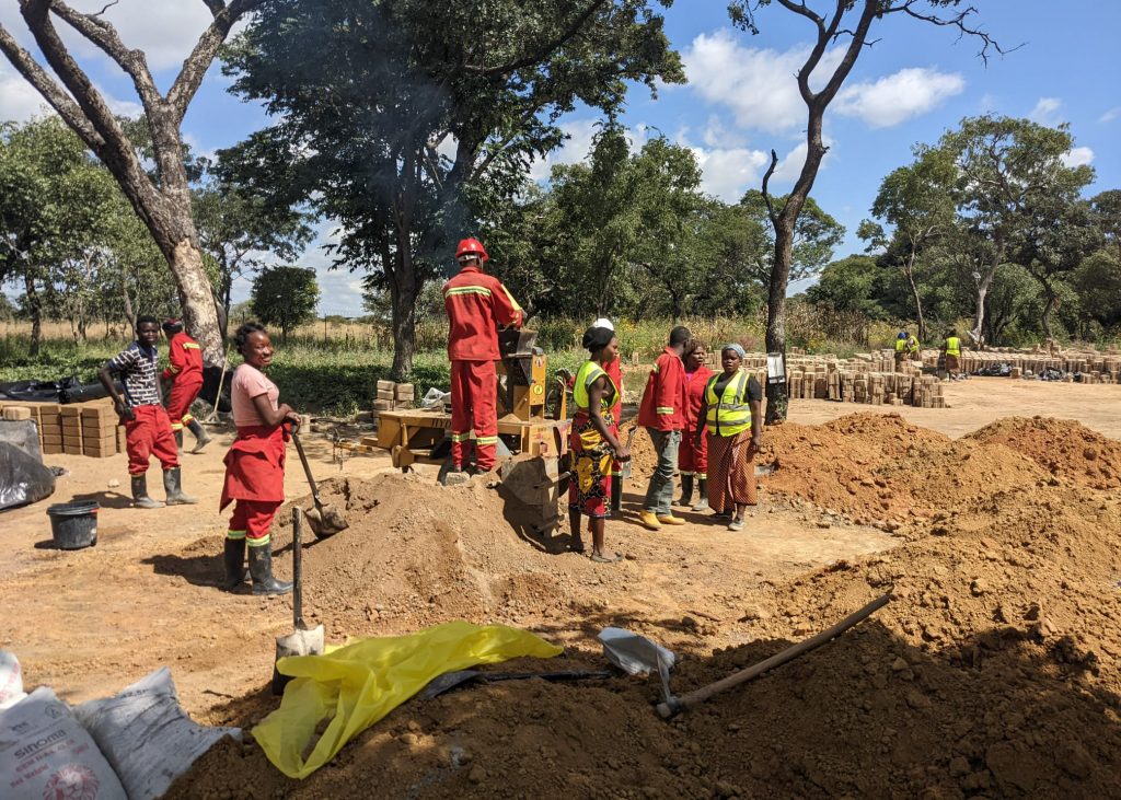 Women working construction alongside men in Zambia.