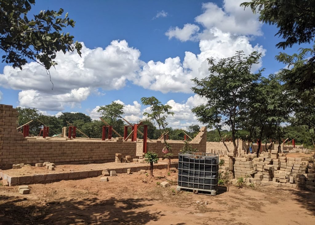 Hydraform blocks next to the construction site as the walls of the buildings are going up.