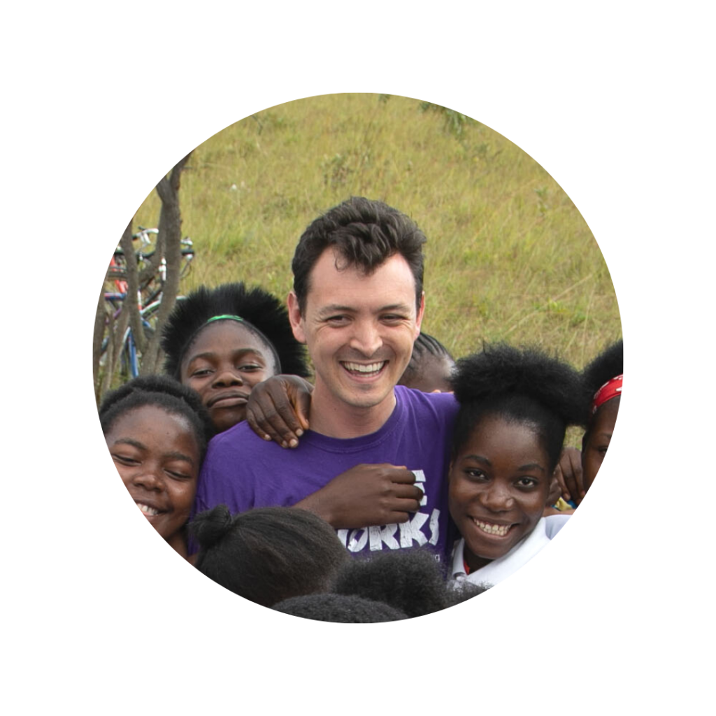Tanner smiling with girls in Zambia in a circle frame.